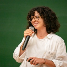 Francesca holding a microphone and talking.